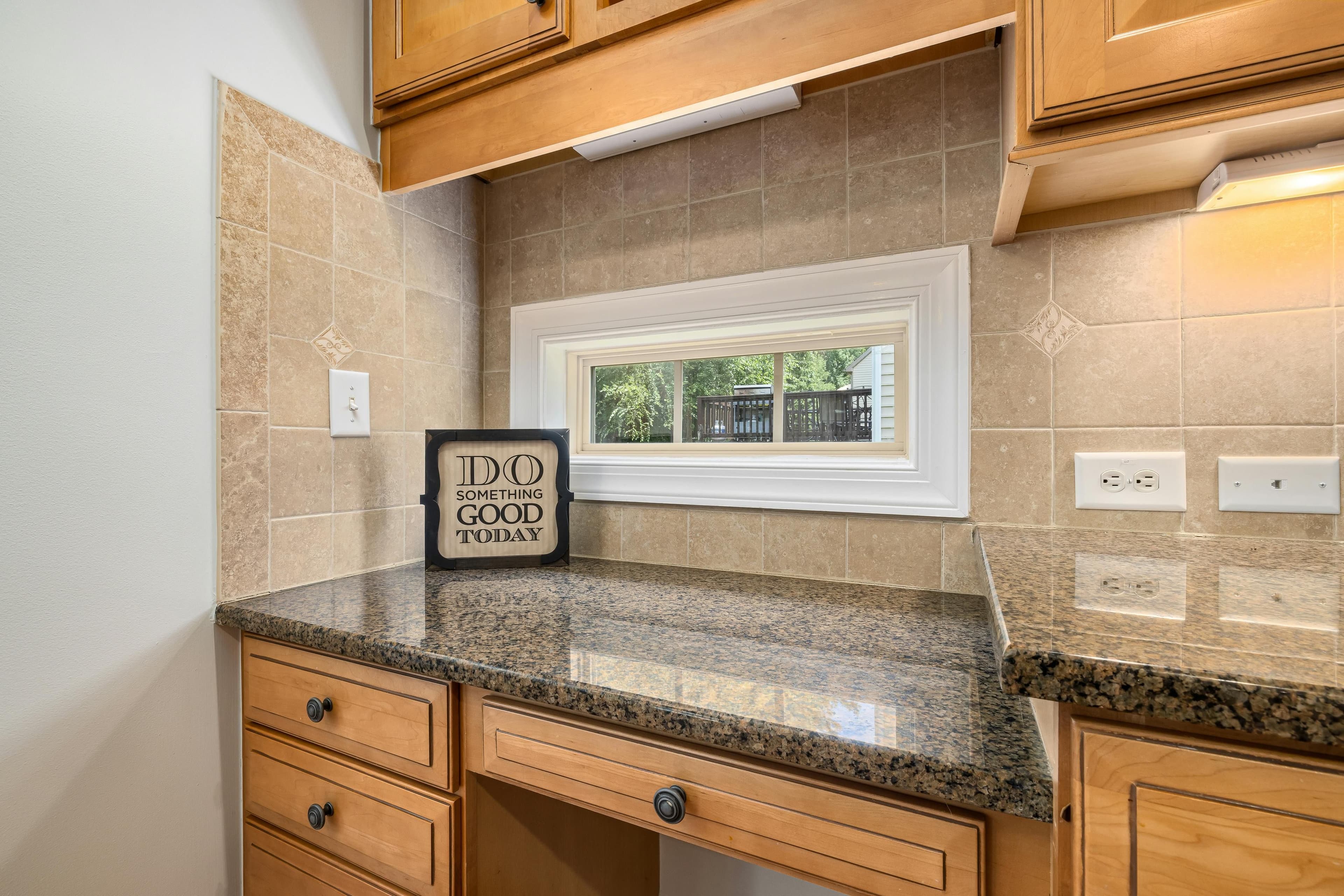 Bright kitchen counter with a small window and an inspirational sign.